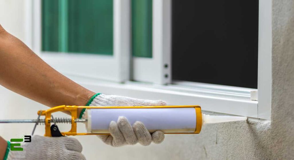 Man applying air seal to window